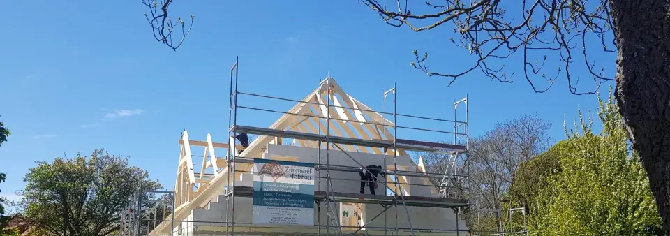 Dachstuhl aus Holz im Sonnenlicht auf einer Baustelle